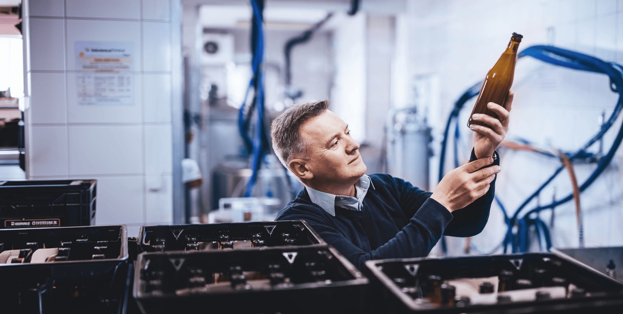 Engineer inspecting a glass bottle on the production floor
